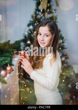 Belle fille mignonne sur un arrière-plan. Vacances de Noël et Nouvel An. Banque D'Images