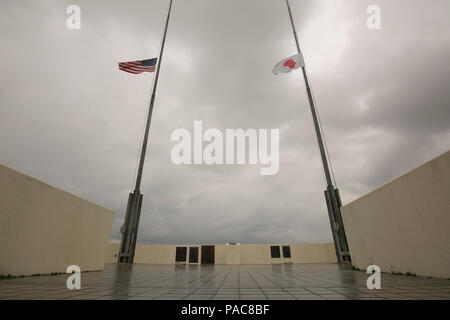 Les drapeaux américains et japonais voler côte à côte en berne 11 mars Camp à bord de Foster, Okinawa, Japon. Les drapeaux sont mis en berne en souvenir du cinquième anniversaire du grand tremblement de terre de Tohoku. Le tremblement de terre de magnitude 9,0 a provoqué des vagues de tsunami jusqu'à 13 étages de haut et conduit à la catastrophe nucléaire de Fukushima. Marines d'Okinawa a conduit les É.-U. Contributions à la mission de récupération appelé Opération Tomodachi, configuration de la commande et le centre de contrôle pour le groupe de travail conjoint pour aider leurs homologues japonais, déménagement de débris pour rouvrir l'aéroport de Sendai pour permettre aux secours d't Banque D'Images