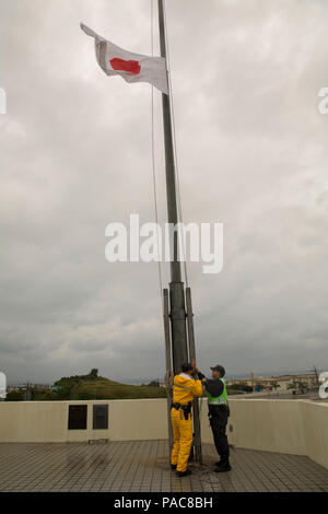 Les agents de sécurité japonais lever le drapeau japonais 11 mars Camp à bord de Foster, Okinawa, Japon. Les drapeaux sont mis en berne en souvenir du cinquième anniversaire du grand tremblement de terre de Tohoku. Le tremblement de terre de magnitude 9,0 a provoqué des vagues de tsunami jusqu'à 13 étages de haut et conduit à la catastrophe nucléaire de Fukushima. Les drapeaux américains et japonais voler côte à côte en berne 11 mars Camp à bord de Foster, Okinawa, Japon. Les drapeaux sont mis en berne en souvenir du cinquième anniversaire du grand tremblement de terre de Tohoku. Le tremblement de terre de magnitude 9,0 a provoqué des vagues de tsunami jusqu'à 13 Banque D'Images