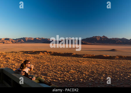 Couple having a picnic sundowner verre au Namib Wolwedans Lodge Banque D'Images