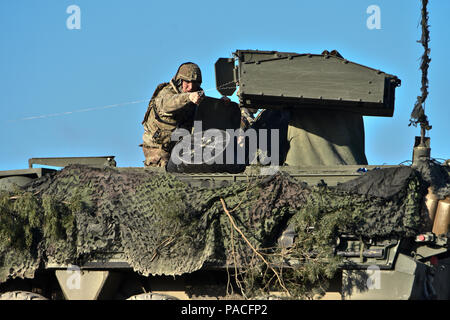 Un soldat affecté à Reaper Troop, 4e Escadron, 2e régiment de cavalerie, coupe une ligne qui a été connecté à l'un des projectiles lancés à coup de son unité M1134 du missile antichar véhicule lors de l'escadron sur l'exercice de tir réel à la zone d'entraînement Grafenwoehr, situé près de la Caserne de Rose, de l'Allemagne, le 15 mars 2016. Le but de l'exercice de tir réel était d'aider à valider la mission du régiment de plates-formes de commande tout en menant une activité d'entraînement de synthèse qui comprend un passage de circulation pour manoeuvrer les capacités. (U.S. Photo de l'armée par le Sgt. William A. Tanner) Banque D'Images