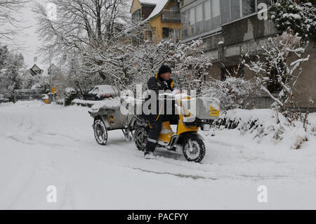 Zürich : Le facteur est la conduite dans la neige avec sa moto Banque D'Images