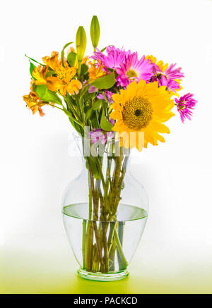 Bouquet attrayant arrangement des fleurs multicolores en vase en verre clair Banque D'Images