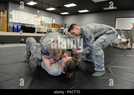 U.S. Air Force combatives Le sergent instructeur Bunkelman Lacey, droite, enseigne à ses collègues 119e Escadron des Forces de sécurité membres Tech. Le Sgt. Elizabeth Miller, haut, et Trisha Campbell Senior Airman légitime défense et forces de sécurité techniques de retenue à la North Dakota Air National Guard Base, Fargo, N.D., le 15 mars 2016. (U.S. Photo de la Garde nationale aérienne capitaine principal Sgt. David H. Lipp/libérés) Banque D'Images