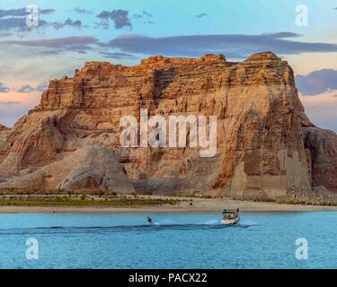 30 mai 2018 - Arizona-Utah, US - un petit bateau remorque une skieur à l'eau passé le géant de falaises sur les rives du lac Powell, réservoir à cheval sur la frontière entre l'Utah et l'Arizona aux États-Unis créé par l'inondation de Glen Canyon par le barrage de Glen Canyon, c'est un endroit de vacances et destination touristique populaire et une partie de la Glen Canyon National Recreation Area administré par le National Park Service. Credit : Arnold Drapkin/ZUMA/Alamy Fil Live News Banque D'Images