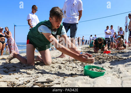 Jantar, Pologne. 21 juillet, 2018. Un compétiteur participe au championnat du monde de chasse Orange Jantar, dans le nord de la Pologne, le 21 juillet 2018. Des centaines de personnes ont participé au Championnat du Monde de chasse orange en finale du Jantar le samedi. Championnat du Monde de la chasse d'Ambre, qui a eu lieu depuis 1998, consiste à prendre et choisir autant d'ambres que possible à l'heure, dans un poste désigné. Les chasseurs peuvent utiliser l'épuisette et d'autres outils. Crédit : Chen Xu/Xinhua/Alamy Live News Banque D'Images