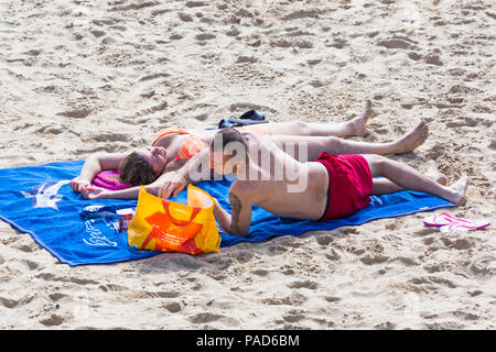 Bournemouth, Dorset, UK. 22 juillet 2018. UK : météo chaude et ensoleillée à Bournemouth plages, comme chef de la mer sunseekers pour prendre le soleil. Couple de bronzer sur une plage. Credit : Carolyn Jenkins/Alamy Live News Banque D'Images