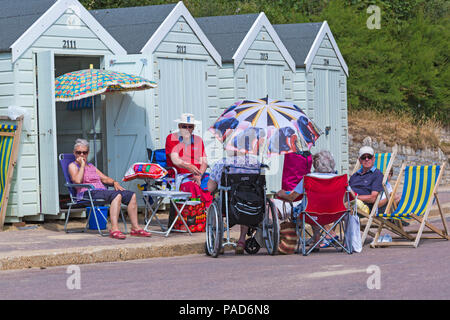 Bournemouth, Dorset, UK. 22 juillet 2018. UK : météo chaude et ensoleillée à Bournemouth plages, comme chef de la mer sunseekers pour prendre le soleil. Les amis de socialiser à l'extérieur des cabines de plage. Credit : Carolyn Jenkins/Alamy Live News Banque D'Images