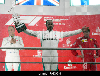 Hockenheim, Allemagne. 22 juillet, 2018. Sport Automobile : Formel-One-Championnats, Grand Prix d'Allemagne à Hockenheim, la race. Lewis Hamilton (C) à partir de la Grande-Bretagne de la Mercedes AMG Petronas Motorsport team célèbre sa victoire sur le podium à la pluie torrentielle avec ses collègues de l'équipe Valtteri Bottas (L) à partir de la Finlande, qui est arrivé en deuxième position. Kimi Räikkönen à partir de la Finlande de la Scuderia Ferrari est l'équipe de la troisième place. Credit : Uli Deck/dpa/Alamy Live News Banque D'Images