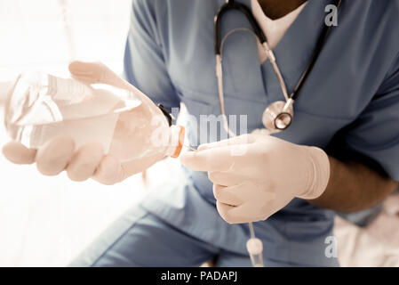 Les mains de cet être dans les gants en caoutchouc Banque D'Images