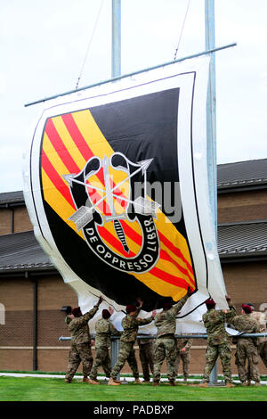 5Th Special Forces Group (Airborne) soldats amassent une bannière représentant le nouveau flash avec l'insigne distinctif de l'unité de l'armée américaine de régiment des forces spéciales au cours de 5e SFG(A) passage flash cérémonie à Fort Campbell, Kentucky, le 23 mars 2016. Au cours de la cérémonie, 5e SFG(A) a rétabli l'époque Vietnam beret, l'ajout d'un flash une bande jaune en diagonale avec trois bandes rouges à l'arrière-plan noir et blanc. Les rayures rendent hommage à l'histoire du groupe dans la guerre du Vietnam et son creuset sous le feu Banque D'Images