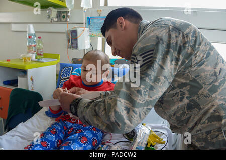 Le s.. Juan Gomez-Navarro, spécialiste des systèmes de carburant avec le F-22 de l'équipe de démonstration, aide l'enfant à construire un avion à l'hôpital San Juan de Dios à Santiago, Chili, 31 mars 2016. Les aviateurs sont au Chili pour participer à l'air et de l'espace FIDAE 2016 Trade Show et consacré une partie de leur temps à visiter les enfants dans plusieurs hôpitaux. (U.S. Air Force photo de Tech. Le Sgt. Heather Redman/libérés) Banque D'Images