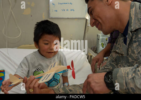 Le s.. Juan Gomez-Navarro, spécialiste des systèmes de carburant avec le F-22 de l'équipe de démonstration, aide l'enfant à construire un avion à l'hôpital San Juan de Dios à Santiago, Chili, 31 mars 2016. Les aviateurs sont au Chili pour participer à l'air et de l'espace FIDAE 2016 Trade Show et consacré une partie de leur temps à visiter les enfants dans plusieurs hôpitaux. (U.S. Air Force photo de Tech. Le Sgt. Heather Redman/libérés) Banque D'Images