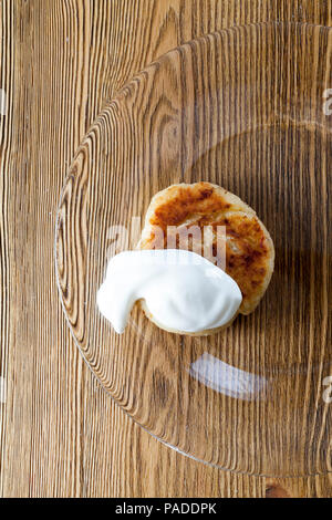 Prêt et délicieux fromage farci avec de la crème sure, libre de repas sur une plaque de verre transparent, qui se trouve sur une vieille table en bois, photo bof Banque D'Images