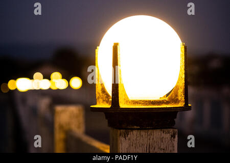 Close up of vintage bollard Lampe témoin sur la balustrade de bois avec bokeh background en période nocturne, selective focus. Banque D'Images