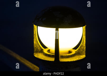 Close up of vintage bollard Lampe témoin sur la balustrade de bois avec bokeh background en période nocturne, selective focus. Banque D'Images