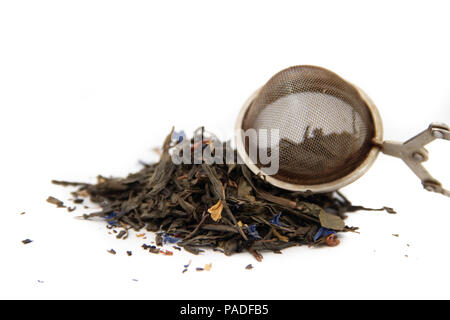 Les feuilles de thé séchées et la cuillère pour le brassage sur un fond blanc. Plateau sur fond blanc Banque D'Images