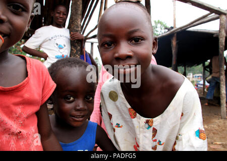 Vue des curieux enfants africains qui se rassemblent autour de la caméra et regardent un site de production d'huile de palme près de Cape Coast au Ghana Banque D'Images