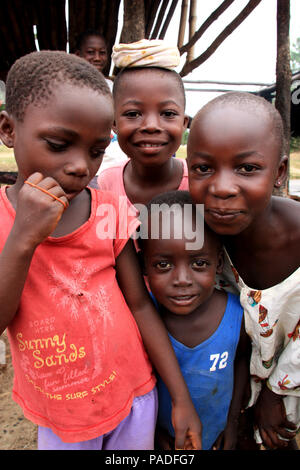 Vue des curieux enfants africains qui se rassemblent autour de la caméra et regardent un site de production d'huile de palme près de Cape Coast au Ghana Banque D'Images