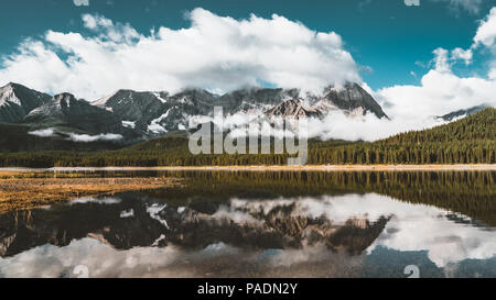 La réflexion avec lac et montagnes low hanging couds au Lac Kananaskis inférieur du parc provincial Peter Lougheed de Kananaskis Alberta Canada Banque D'Images