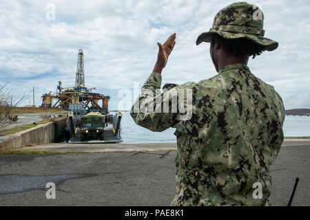 PUERTO RICO, (sept. 25, 2017) - Maître de Manœuvre 2e classe Chelsea Cowans, attribué à Beach Master Unit deux guides, un polyvalent à grande mobilité des véhicules à roues sur le pont d'un utilitaire de débarquement à Puerto Rico, 25 septembre 2017. Le ministère de la Défense soutient Federal Emergency Management Agency (FEMA), le principal organisme fédéral, en aidant les personnes touchées par l'Ouragan Maria afin de minimiser la souffrance et est une composante de l'ensemble de l'intervention. Banque D'Images