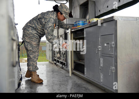Les cuisiniers de Wiesbaden solides équipes Cafe de la salle à manger (MAEC) a une cuisine mobile Remorque (MKT) vers l'installation gamme régionale Wackernheim le 30 mars 2016 pour nourrir les soldats de l'armée américaine l'Europe. Ici la CPS. Santiago-Lopez Michelle qui a contribué à la préparation des repas est à la recherche d'un ustensile servant à utiliser. Le MKT est compact, mais tout a une place à l'intérieur. Après une longue période de ne pas être utilisé, c'est la première fois que le MKT a été créé pour être utilisé par les cuisiniers pour les soldats. (U.S. Photo de l'armée de l'information visuelle Dee Spécialiste Crawford/libérés) Banque D'Images