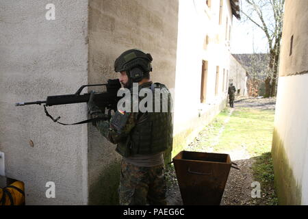 Un soldat allemand de la 12e Brigade blindée, 10e Panzer Division fournit la sécurité tout en menant des opérations urbaines pendant l'exercice 16 à la jonction de Sabre de l'armée américaine de préparation interarmées multinationale Centre à Hohenfels, Allemagne, le 31 mars 2016. Sortie 16 Sabre de l'armée américaine est la 173e Brigade aéroportée de l'Europe centre de formation de combat de l'exercice de certification, qui aura lieu au Centre de préparation interarmées multinationale à Hohenfels, Allemagne, Mars 31-avr. 24, 2016. L'exercice est conçu pour évaluer le niveau de préparation de l'Armée de l'Europe pour mener des brigades de combat terrestre unifiée Banque D'Images