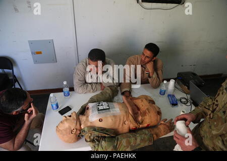 Des soldats iraquiens, inscrits dans le vol de l'Iraq, bien sûr des infirmiers de discuter des méthodes de traitement au cours de la poitrine et de traumatisme abdominal s'entraîner au Camp Taji, Irak, le 31 mars 2016. Les médecins de l'armée américaine a formé les soldats irakiens dans une variété de techniques médicales et techniques de sauvetage. Cette formation fait partie de la Force opérationnelle interarmées combinée globale - Fonctionnement résoudre inhérent à la mission de renforcer les capacités des partenaires pour accroître la capacité militaire des Forces de sécurité iraquiennes la lutte contre l'Etat islamique d'Irak et du Levant. (U.S. Photo de l'armée par le Sgt. Kalie Jones/libérés) Banque D'Images