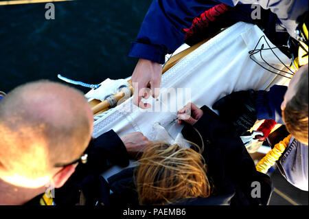 L'équipage de l'Aigle de la Garde côtière de réparer les voiles pendant qu'ils sont en cours dans l'océan Atlantique, le mercredi 23 mars 2016. L'équipage est formé pour réparer les dommages subis, en mer. U.S. Coast Guard photo de Maître de 2e classe Matthew S. Masaschi. Banque D'Images