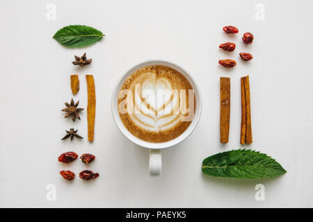 Télévision jeter une tasse de délicieux cappuccino frais sur une surface blanche et de divers ingrédients. Banque D'Images