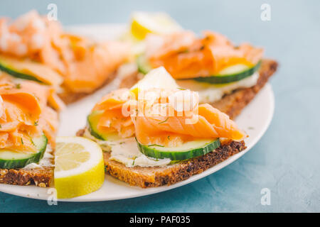 Des sandwichs appétissants des toasts avec du saumon, des légumes et fromage à la crème servi sur assiette. Prêt à manger. Boutique suédoise Banque D'Images