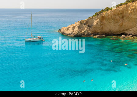 Un bateau navigue dans les eaux de la mer turquoise de la plage de Porto Katsiki à Lefkada île Ionienne en Grèce Banque D'Images