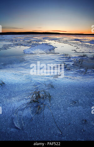 Coucher du soleil à un lac gelé en Muonio, Laponie, Finlande Banque D'Images