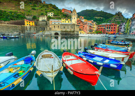 Superbe soirée nuageux, célèbre lieu touristique avec Vernazza harbour fantastique et bateaux de pêche en bois colorés, Cinque Terre, Ligurie, Italie, Europe Banque D'Images