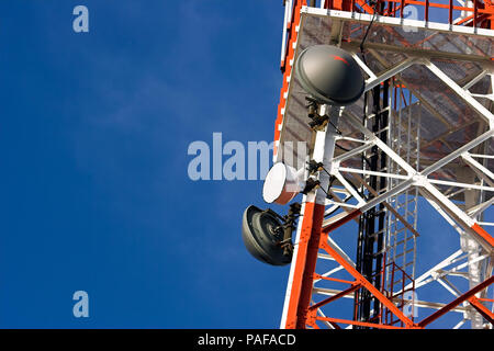 La tour rouge et blanc de la communication avec leurs antennes contre le ciel bleu Banque D'Images