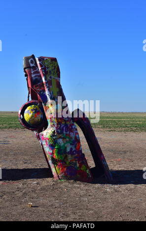 Peint à la bombe colorée des cadillacs coincé dans le sol. Banque D'Images