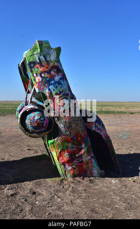 Cadillacs colorées et peint à la bombe la moitié dans la terre connue sous le nom de Cadillac Ranch. Banque D'Images