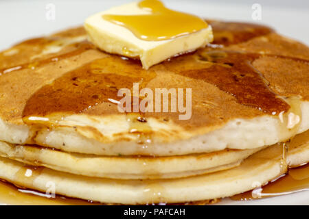 Pancake avec un carré de beurre et de sirop sur une table de cuisine en attente d'être mangés Banque D'Images