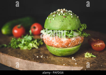 L'avocat vegan burger de lentilles avec pattie sur planche à découper en bois, vue rapprochée. Burger sain Banque D'Images