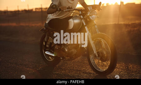 Cropped shot of male biker riding vite sur son vélo. Homme conduisant une moto rapide country road. Banque D'Images