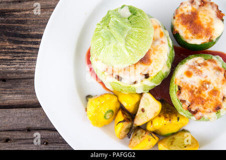 Courgette farcie ronde balle avec le quinoa et fromage servi avec poivrons patty pan squash Banque D'Images