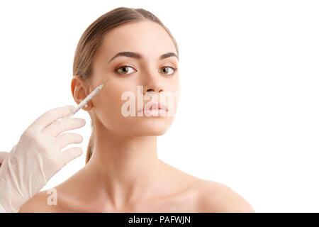 Portrait d'une jolie jeune femme qui reçoit un traitement de botox. Isolé sur fond blanc. Banque D'Images