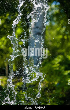 La chute de l'eau transparent flux vertical contre un ciel bleu et vert paysage, close-up Banque D'Images