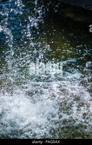 La chute de l'eau transparent flux vertical contre un ciel bleu et vert paysage, close-up Banque D'Images