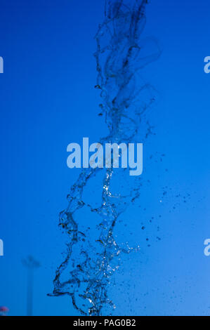 La chute de l'eau transparent flux vertical contre un ciel bleu et vert paysage, close-up Banque D'Images
