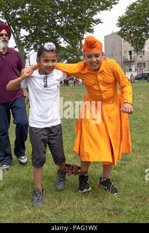 Deux jeunes garçons les garçons en compétition dans une course à trois pattes le Sikh Jeux Gurmat à Smokey Park dans le sud de Richmond Hill, Queens, New York. Banque D'Images