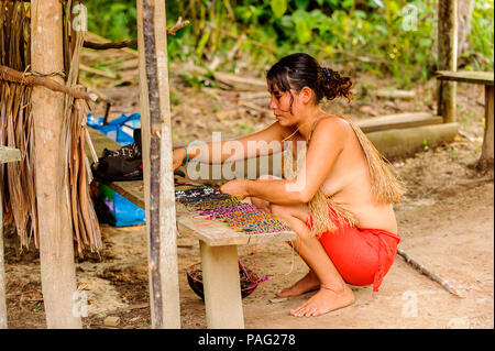 L'AMAZONIE, PÉROU - 10 NOV 2010 : une femme indigène amazonienne non identifié, vend des souvenirs aux touristes. Les populations autochtones de l'Amazonie sont protégés par Banque D'Images
