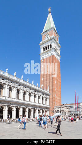 Les touristes en face de St Marks Campanile et la Bibliothèque Nationale Marciana, Piazetta San Marco, San Marco, Venise, Vénétie, Italie. Femme avec parasol Banque D'Images