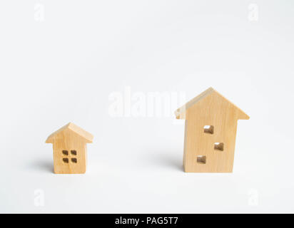 Deux maisons en bois sur un fond blanc. Une grande maison mieux puis une petite. Le concept de l'achat d'une maison privée ou un appartement. Choix du type de Banque D'Images