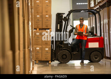 Worker with clipboard in warehouse Banque D'Images